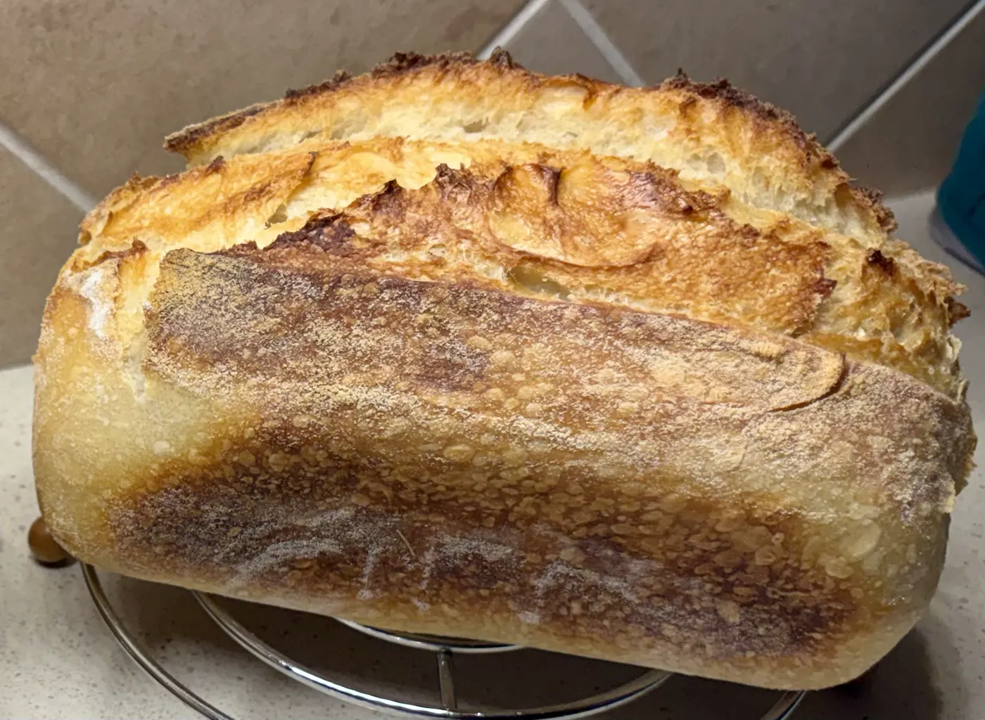 Golden artisan sourdough loaf cooling on a rack